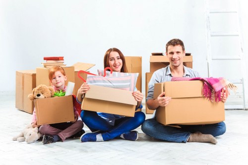 Movers organizing household items with packing supplies in Newham