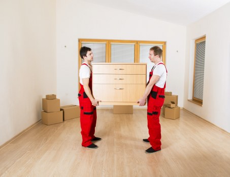 Piano movers protecting floors and walls during a Newham move